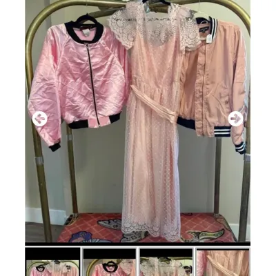 Sale Photo Thumbnail #102: Trio of pink vintage-style apparel including a lace-overlay maxi dress and two satin bomber jackets displayed on a clothing rack.