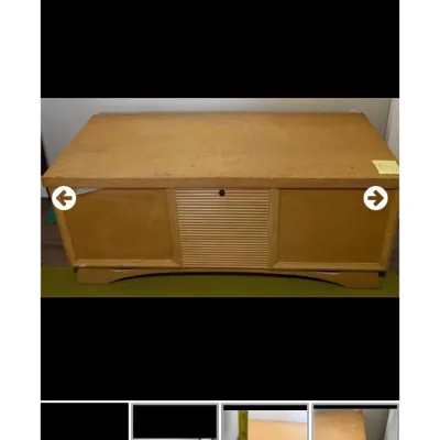 Sale Photo Thumbnail #46: Mid-century blonde wood cedar chest featuring a central tambour-style panel and curved base, showing minor surface wear.