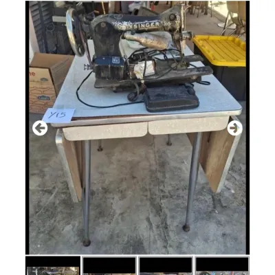 Sale Photo Thumbnail #69: Vintage electric Singer sewing machine with attached motor light resting on a Formica drop-leaf utility table.