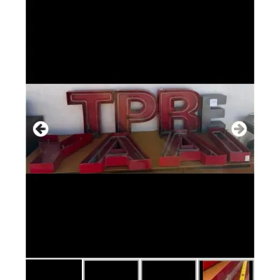 Collection of vintage red and metal channel marquee sign letters displaying various letters including T, P, R, E, Y, and A.
