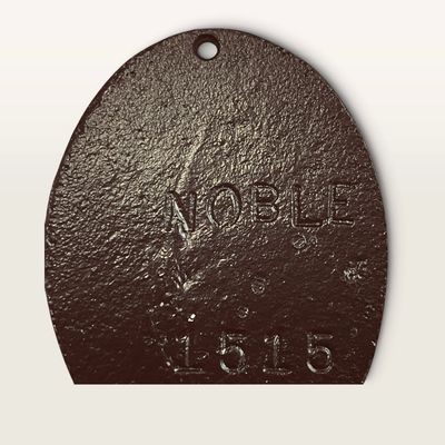 Vintage cast iron door plaque or marker featuring embossed text reading 'NOBLE' and '1515'.