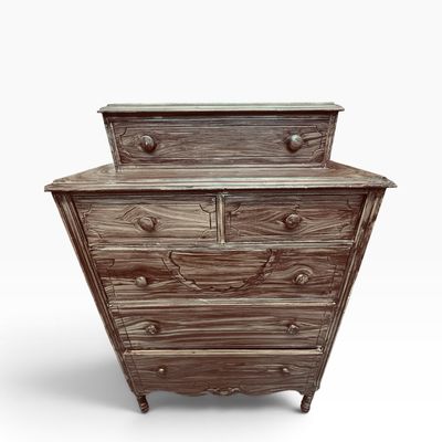 Rustic whitewashed wooden dresser featuring a top tier box drawer, multiple lower drawers with wooden knobs, and an ornate carved detail.