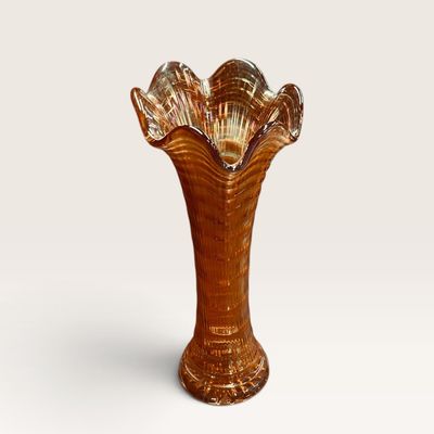 Vintage marigold carnival glass vase featuring a ruffled rim and ribbed texture.