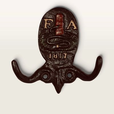 Vintage cast iron Fire Association of Philadelphia double wall hook, featuring the classic fire plug and hose motif with '1817'...