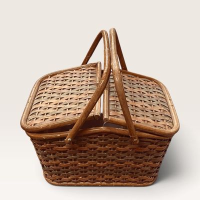 Vintage woven wicker picnic basket featuring dual bentwood handles and split-top hinged lids.