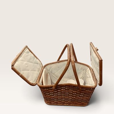 Vintage woven wicker picnic basket with double folding lids, quilted fabric lining, and double handles.