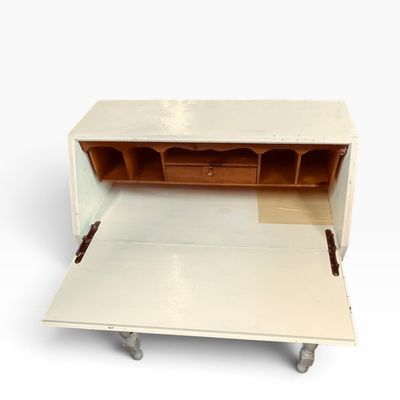 White-painted drop-front secretary desk with a natural wood interior organizer and turned silver-toned legs.