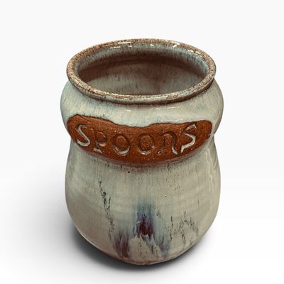 Sale Photo Thumbnail #30: Handcrafted studio pottery spoon holder crock featuring a light grey glaze over exposed terra cotta with the word SPOONS impressed on the front.