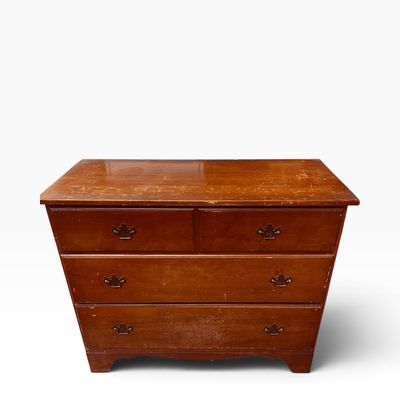 Vintage Colonial Revival style wooden dresser with four drawers and brass batwing bail handles, featuring visible surface wear and...