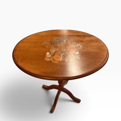 Oval wooden pedestal side table featuring a central floral and fruit inlay motif on the tabletop.