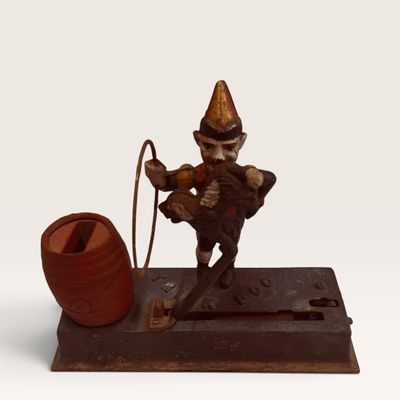 Antique Hubley "Trick Dog" cast iron mechanical bank, featuring a painted clown, hoop, and dog mechanism with an integrated...