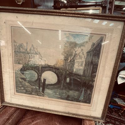 Sale Photo Thumbnail #7: Large framed landscape print depicting a stone bridge and European canal scene, housed in an ornate carved wood frame.