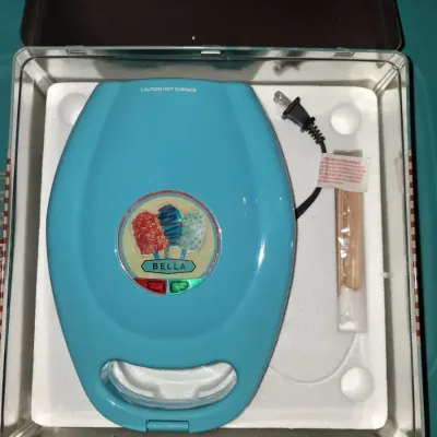 Sale Photo Thumbnail #682: BELLA CAKESICLE MAKER IN ORIGINAL TIN LUNCHBOX STYLE STORAGE BOX. INCLUDES MAKER, INSTRUCTION MANUAL, DECORATING SYRINGE TOOL, STICKS AND MORE. APPEARS LIGHTLY USED OR UNUSED IN ORIGINAL PACKAGING.