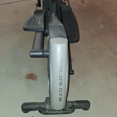 Sale Photo Thumbnail #650: THIS IS LOCATED IN THE BASEMENT 
GOLD'S GYM STRIDE TRAINER ELLIPTICAL MACHINE. FEATURES ADJUSTABLE STRIDE, DIGITAL DISPLAY CONSOLE WITH WORKOUT PROGRAMS, BUILT-IN FAN, RESISTANCE CONTROLS, AND HEART RATE GRIPS. LIGHT SURFACE DUST AND PREVIOUS USE WEAR VIS