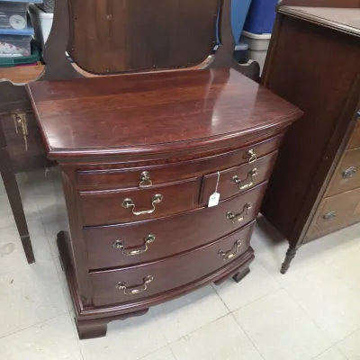 Sale Photo Thumbnail #28: Vintage dark wood bow-front vanity dresser featuring brass batwing drawer pulls and an attached harp mirror frame.