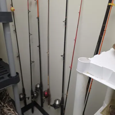 Sale Photo Thumbnail #68: Assortment of fishing rods equipped with spincast reels leaning against a wall, including bobbers attached to the lines.