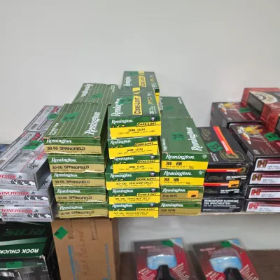 Sale Photo Thumbnail #92: Collection of boxed rifle ammunition, featuring Remington Core-Lokt 30-06 Springfield and .308 Win, along with Winchester and Hornady boxes, an RCBS Rock Chucker reloading press box, and packaged accessories.