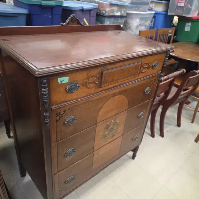 Sale Photo Thumbnail #29: Antique mahogany chest of drawers with two-tone veneer inlays, decorative drop handles, and carved accents.