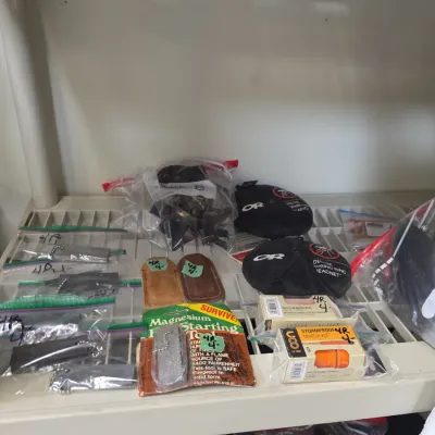 Sale Photo Thumbnail #57: Collection of outdoor and survival gear, including magnesium fire starter tools, UCO stormproof match kits, and Outdoor Research headnets.