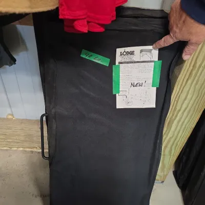 Sale Photo Thumbnail #147: Lodge brand camp Dutch oven cooking table inside a black canvas carrying case, marked new.