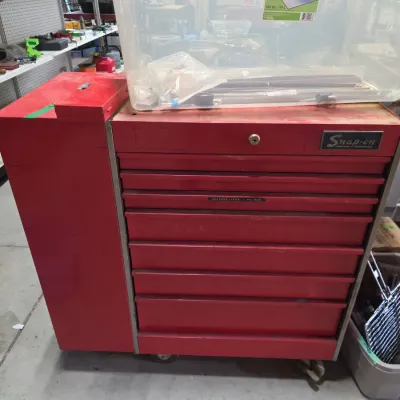 Sale Photo Thumbnail #103: Vintage red Snap-on rolling tool chest with side cabinet attachment, showing light surface wear and heavy-duty steel construction.