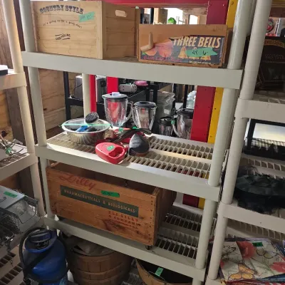 Sale Photo Thumbnail #116: Plastic utility shelving unit organized with vintage wooden crates, blenders, pet supplies, and bushel baskets.