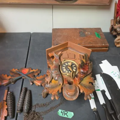 Sale Photo Thumbnail #48: Traditional Black Forest hand-carved wooden cuckoo clock, featuring carved rabbit and game bird details, complete with pinecone weights, pendulum, and top crown piece.