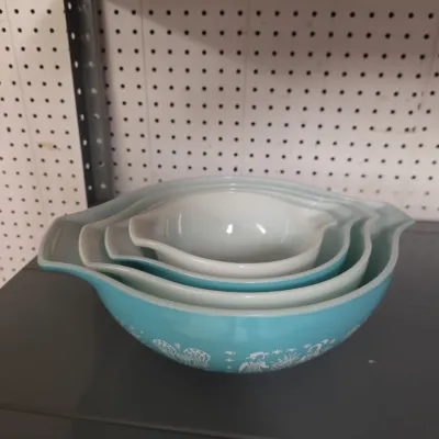 Sale Photo Thumbnail #36: Vintage Pyrex Butterprint turquoise mixing bowl set, featuring a stack of Cinderella-style handled bowls displayed on a shelf.