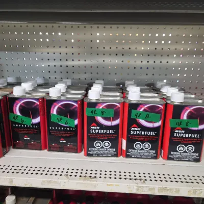 Sale Photo Thumbnail #135: Collection of MSR Superfuel liquid camp stove fuel cans displayed on retail pegboard shelving.