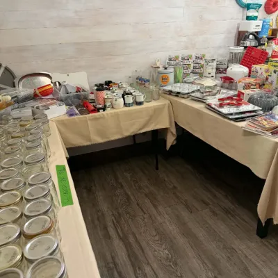Sale Photo Thumbnail #20: Collection of kitchen items arranged on tables, including numerous glass canning jars, ceramic mugs, bakeware, and small appliances.