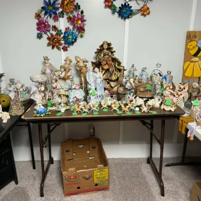 Sale Photo Thumbnail #7: Large collection of porcelain and ceramic figurines featuring vintage European-style statues, religious figures.