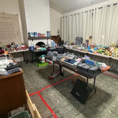 Sale Photo Thumbnail #17: Living room setup filled with various estate sale items, including electronics, toys, stuffed animals, and household goods.