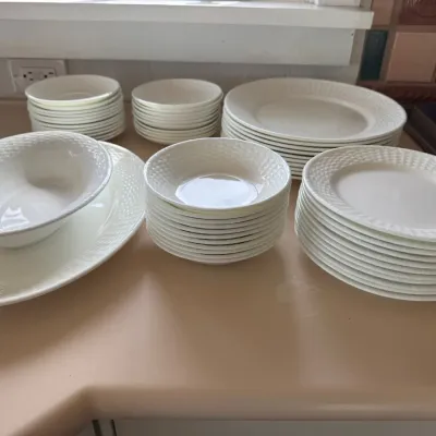 Sale Photo Thumbnail #32: Large service of white ceramic dinnerware with a basketweave texture along the borders, including dinner plates, salad plates, bowls, and serving pieces.