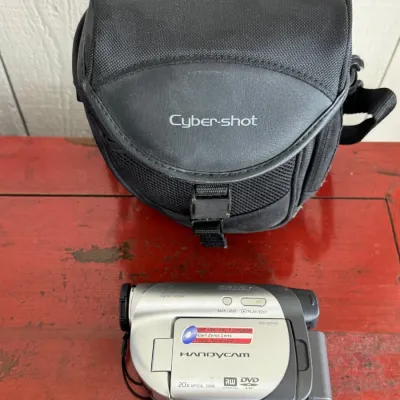 Sale Photo Thumbnail #23: Sony Handycam DCR-DVD105 camcorder with Carl Zeiss lens, complete with a black Sony Cyber-shot padded carrying bag, circa mid-2000s.