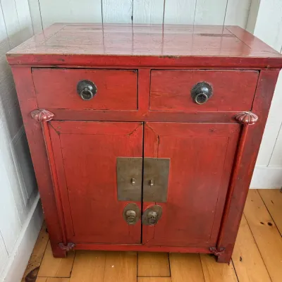 Sale Photo Thumbnail #30: Chinese red lacquered wooden cabinet featuring two upper drawers and lower double doors with traditional brass hardware.