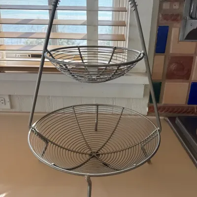 Sale Photo Thumbnail #45: Two-tier wire fruit basket display stand with a coiled top handle and tripod feet.