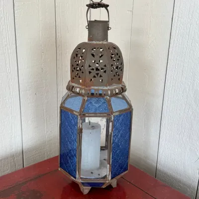 Sale Photo Thumbnail #48: Moroccan-style metal and blue patterned glass candle lantern featuring a pierced metal dome top and hanging ring.