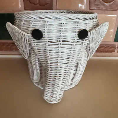 Sale Photo Thumbnail #42: Vintage white woven wicker elephant head wastebasket with black button eyes and floppy ears.