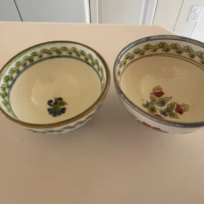 Sale Photo Thumbnail #35: Pair of hand-painted glazed ceramic bowls featuring green vine borders and central floral motifs.