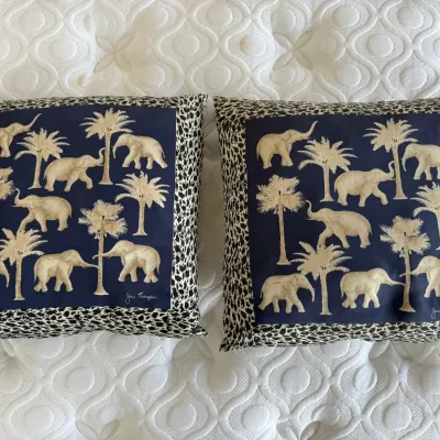Sale Photo Thumbnail #54: Pair of Jim Thompson silk throw pillows featuring embroidered elephants and palm trees on navy centers, trimmed with a leopard print border.
