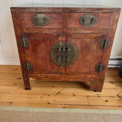 Sale Photo Thumbnail #14: Antique Chinese Asian-style wooden cabinet featuring two top drawers and a double-door lower compartment with traditional brass hardware and decorative round plates.