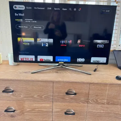 Sale Photo Thumbnail #53: Samsung flat-screen Smart TV on a quadruped chrome base, displayed on a light wood dresser.
