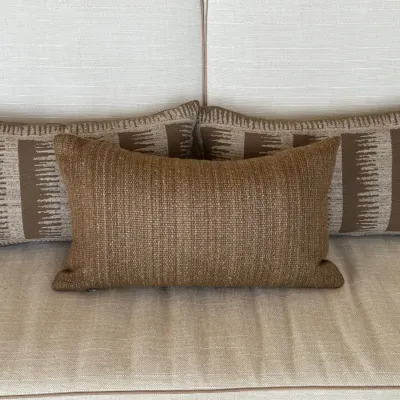 Sale Photo Thumbnail #20: Set of three rectangular accent throw pillows, including two with a brown geometric ikat-style pattern and one solid textured bronze lumbar pillow.