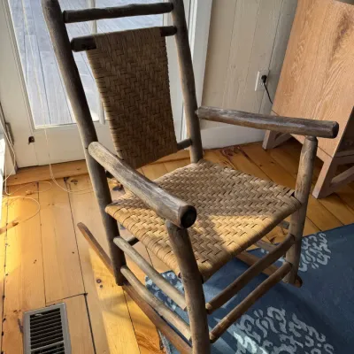 Sale Photo Thumbnail #51: Rustic Adirondack-style log rocking chair featuring a woven cane or splint seat and backrest panel.