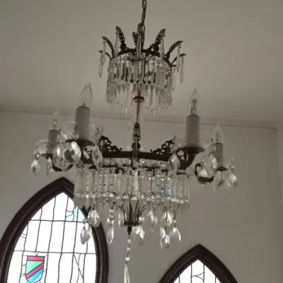 Sale Photo Thumbnail #81: Vintage bronze and crystal chandelier featuring a multi-tier design with hanging prisms and multiple candle-style lights.