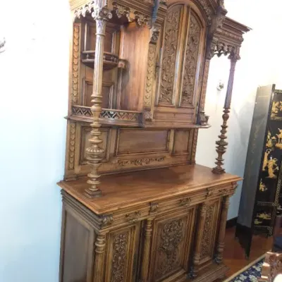Sale Photo Thumbnail #10: Ornately carved Victorian Renaissance Revival walnut hutch cabinet featuring elaborate relief carvings, turned columns, and decorative gallery trim.