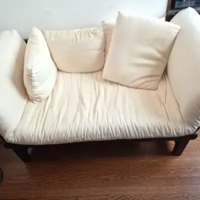 Sale Photo Thumbnail #96: Contemporary daybed sofa with a dark wood frame, cream fabric upholstery, and matching accent pillows.