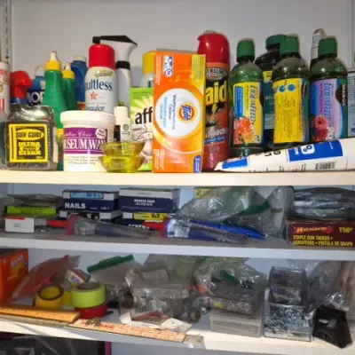 Sale Photo Thumbnail #165: Storage shelves filled with assorted household cleaning supplies, pesticides, plant foods, hardware, and miscellaneous workshop items.