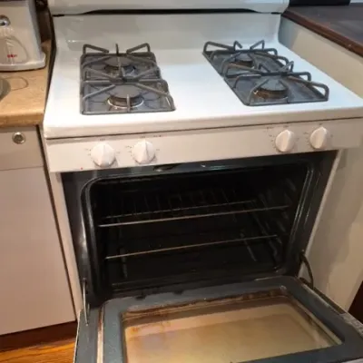 Sale Photo Thumbnail #147: White Hotpoint freestanding gas stove and oven with a four-burner cooktop, digital control panel, and open oven door.