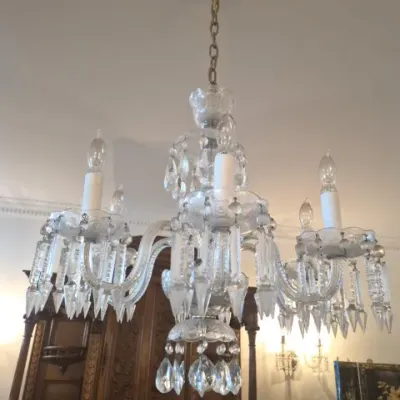 Sale Photo Thumbnail #82: Vintage crystal chandelier with multi-tiered design, hanging prisms, and faux candle sleeves.